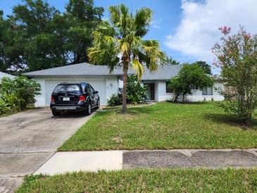 Charming single-story home with a well-maintained lawn and mature landscaping, and a modern SUV parked in the driveway at 5523 Westview Dr, Orlando, FL 32810
