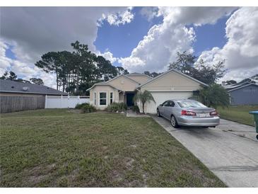 Charming single-story home with a well-manicured lawn, attached garage, and traditional architectural details at 2921 Blackburn Ave, Deltona, FL 32738