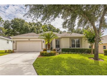 Charming single-story home with well-manicured lawn and inviting front yard landscaping with a two-car garage at 2000 Farmington Ct, Clermont, FL 34711