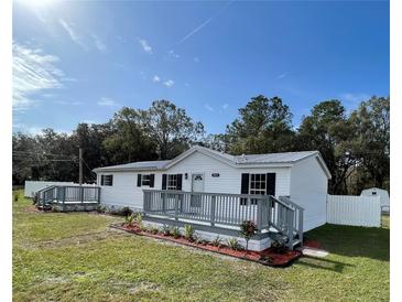 Newly remodeled single-wide home with gray deck and fenced yard at 7612 Glen Meadow Dr, Lakeland, FL 33810