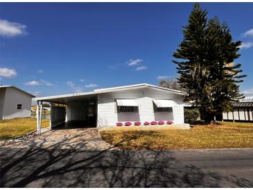 Charming single-story home with a carport and well-maintained landscaping at 2055 S Floral Ave # 73, Bartow, FL 33830