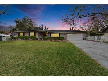 Charming brick home with well-manicured lawn, mature trees and a two-car garage at 4523 Hallamview Ln, Lakeland, FL 33813