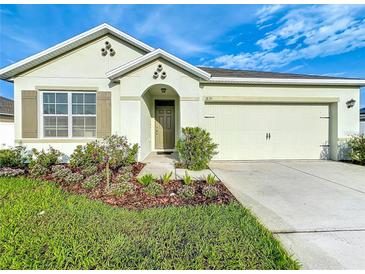 Charming single-story home features a well-manicured lawn and a two-car garage at 1835 Jackson Oaks Dr, Bartow, FL 33830