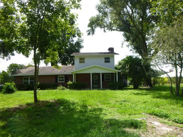 Charming two-story home featuring a brick facade, inviting front porch, and mature trees at 1835 Mount Pisgah Rd, Fort Meade, FL 33841