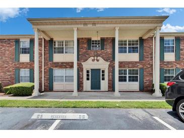 Attractive brick condo building featuring a covered entrance with stately columns and green shutters at 1920 E Edgewood Dr # D7, Lakeland, FL 33803
