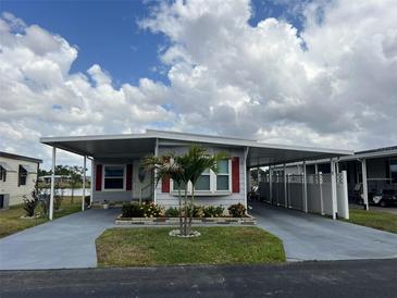 Charming home with a covered driveway, complemented by a beautifully landscaped yard and red window frames at 2055 S Floral Ave # 69, Bartow, FL 33830