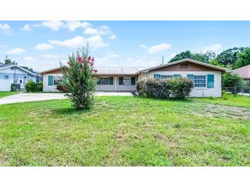 Charming single-story home featuring a metal roof, green shutters, and lush front yard at 900 Howard Nw Ter, Winter Haven, FL 33881