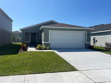 Charming single-story home featuring a two-car garage, neat landscaping, and a well-maintained lawn at 2366 Aquiline Nest St, Eagle Lake, FL 33839