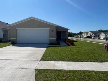Charming single-story home featuring a well-maintained lawn and a two-car garage at 2374 Aquiline Nest St, Eagle Lake, FL 33839