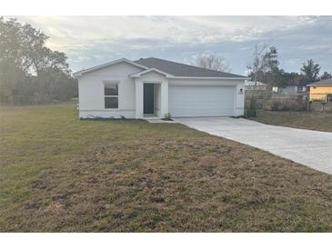 White house with a garage and spacious yard at 2322 Sw 146Th Loop, Ocala, FL 34473