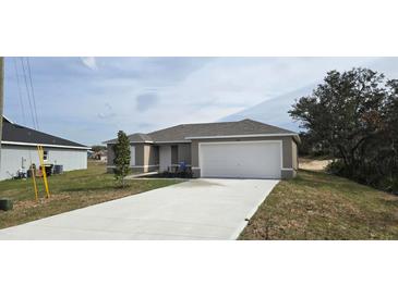 New single-story home with attached garage and landscaped front yard at 1807 Don Pl, Poinciana, FL 34759