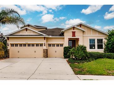 Two-story house with three-car garage, stone accents, and lush landscaping at 30120 Hackney Loop, Mount Dora, FL 32757