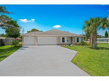 Charming single-story home with a well-manicured lawn, two-car garage, and beautiful landscaping at 1840 India Palm Dr, Edgewater, FL 32141