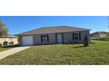 Charming single-story home featuring a well-maintained lawn, an attached garage, and a welcoming front entrance at 521 Cardinal Dr, Poinciana, FL 34759