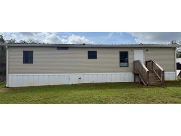 Exterior shot of manufactured home showing siding, stairs to front door, and front lawn at 3123 Crystal Hills Dr, Lakeland, FL 33801