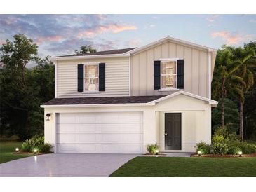 Charming two-story home with a two-car garage, well-maintained lawn, and complementary landscaping at 1988 Golden Beak Dr, Eagle Lake, FL 33839