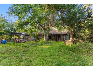 Exterior view of a home with a grassy lawn and trees surrounding it at 1915 Poinsettia Dr, Port Orange, FL 32128