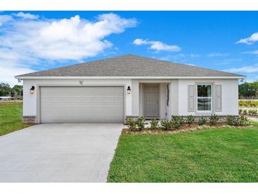 Charming one-story home featuring a neutral color palette, well-manicured landscaping, and an attached two-car garage at 18 Haddock Way, Poinciana, FL 34759