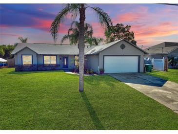 Single-story home with gray exterior, attached garage, and well-maintained lawn at 1545 Huntington St, Deltona, FL 32725