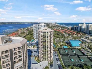 Aerial view of condo building with ocean and city views, tennis courts, and pool at 1 Oceans West Blvd # 16A4, Daytona Beach, FL 32118