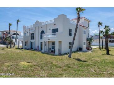 Exterior of a three-story beach house with a Spanish style, manicured lawn, and ocean views at 3072 Ocean Shore Blvd, Ormond Beach, FL 32176