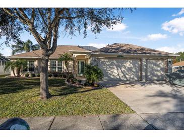 Tan house with a three-car garage and lush landscaping at 35 Saddlers Run, Ormond Beach, FL 32174