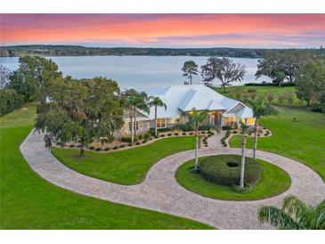 Luxury lakefront home with circular driveway and landscaped grounds at 38338 Timberlane Dr, Umatilla, FL 32784