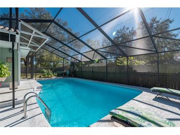 The screened-in pool features a bright blue interior, a ladder, lounge chairs, and access to the house at 5700 E Fort King St, Ocala, FL 34470