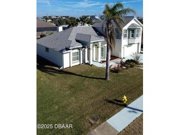 Aerial view of a single-Gathering home with a large yard and palm trees at 105 Barrier Isle Dr, Ormond Beach, FL 32176