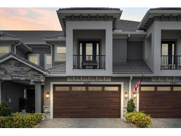 Modern two-story townhome with a dark brown garage door and balcony at 2840 Isles Way, New Smyrna Beach, FL 32168