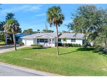 White single story home with palm trees and manicured lawn at 35 Country Club Dr, Ormond Beach, FL 32176