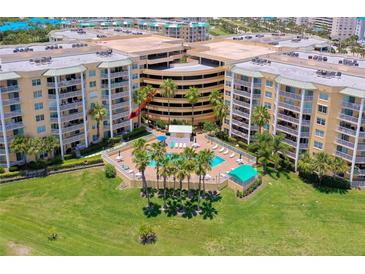 Aerial view of condo building with pool and lush landscaping at 4670 Links Village Dr # B201, Ponce Inlet, FL 32127