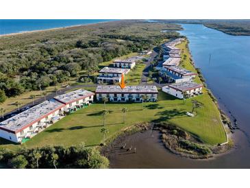 Scenic aerial view of waterfront condos surrounded by lush greenery and overlooking tranquil waters at 66 Ocean Palm Villa S, Flagler Beach, FL 32136