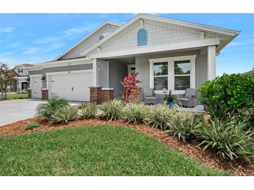 Gray two-story house with a two-car garage, landscaped yard, and a covered porch at 2840 Monaghan Dr, Ormond Beach, FL 32174