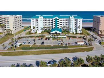 Aerial view of a beachfront condominium building with parking and ocean views at 4641 S Atlantic Ave # 2010, Port Orange, FL 32127