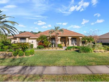 Beautiful one-story home with landscaped lawn and palm trees at 1011 Hampstead Ln, Ormond Beach, FL 32174