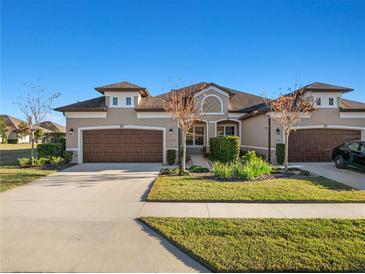 Tan two-story house with brown doors and landscaping at 1510 Kinnard Cir, Ormond Beach, FL 32174