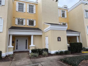 Two-story building exterior with yellow facade and white trim at 7518 Seven Eagles Way # 201, Reunion, FL 34747