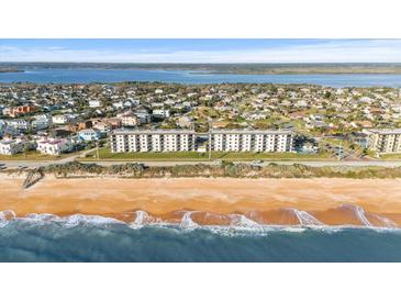 Aerial view of beachfront condo building with ocean and town views at 3100 Ocean Shore Blvd # 5020, Ormond Beach, FL 32176