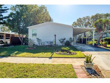 Single-wide manufactured home with carport and landscaped lawn at 718 Casper Ave, Port Orange, FL 32129