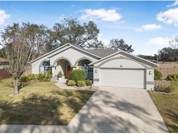 Single-story house with arched entryway, two-car garage, and well-maintained lawn at 92 Spinnaker Cir, South Daytona, FL 32119