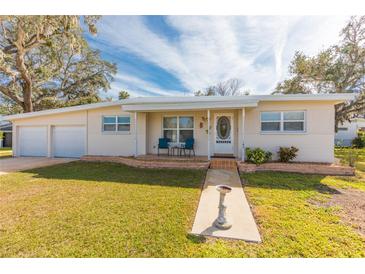 Cute ranch home with attached two-car garage and landscaped lawn at 105 Park Cir, Daytona Beach, FL 32117