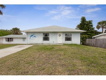 Charming single-story home with a well-maintained lawn and unique dolphin artwork at 5 Alamanda Dr, Ormond Beach, FL 32176