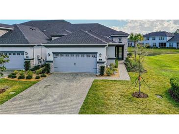 Charming home featuring a gray-tone garage door, lush landscaping, and a welcoming walkway at 131 Longridge Ln, Ormond Beach, FL 32174