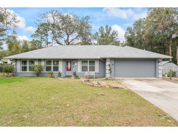 Charming single story home with a well-manicured lawn, red door, and two-car garage in a suburban neighborhood at 290 Birch Ave, Orange City, FL 32763