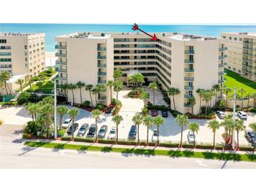 An exterior shot of a condo complex with manicured landscaping, palm trees and a blue ocean in the background at 4555 S Atlantic Ave # 4708, Port Orange, FL 32127