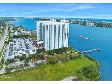 Stunning aerial view of a waterfront condo building surrounded by lush greenery and blue waters at 231 Riverside Dr # 1907-1, Holly Hill, FL 32117