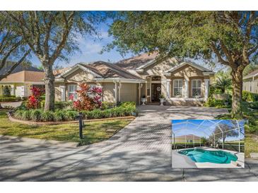 Charming single-story home with lush landscaping, brick driveway, and attached two-car garage at 5 Captiva At Lionspaw, Daytona Beach, FL 32124