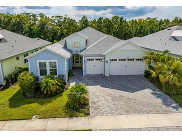 Charming single-story home showcasing a brick driveway, three-car garage, and lush landscaping at 753 Attitude Ave, Daytona Beach, FL 32124