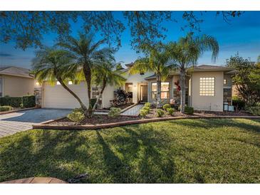 Charming single-story home with a manicured lawn, lush tropical landscaping, and a brick-paved driveway at 187 Indian Wells Ave, Kissimmee, FL 34759